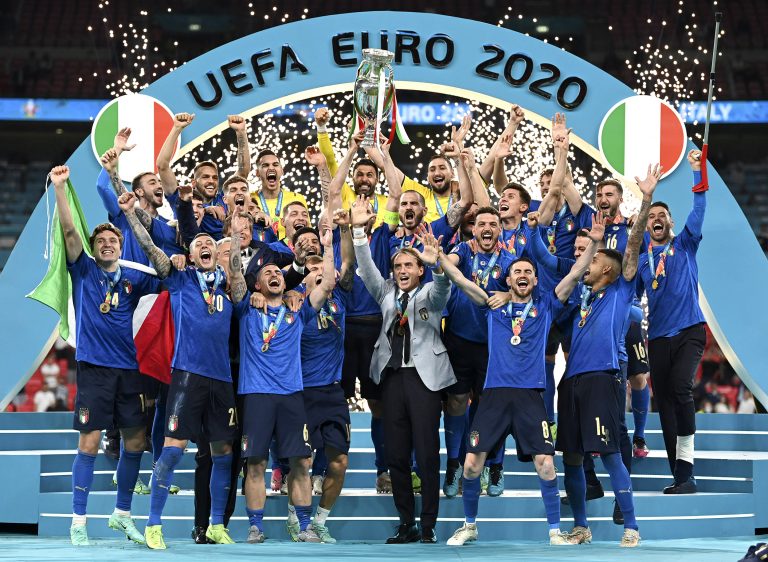 Italy&#039;s team celebrates with the trophy on the podium after winning the Euro 2020 soccer championship final between England and Italy at Wembley stadium in London, Sunday, July 11, 2021. (Michael Regan/Pool via AP)