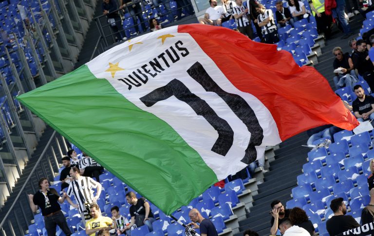 FILE PHOTO: Soccer Football - Coppa Italia - Final - Juventus v Inter Milan - Stadio Olimpico, Rome, Italy - May 11, 2022 A Juventus fan waves a flag inside the stadium before the match REUTERS/Ciro De Luca